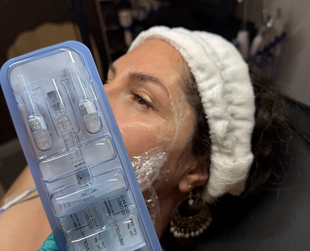 A tray of prepared syringes beside a client at Roniya Aesthetic Clinic